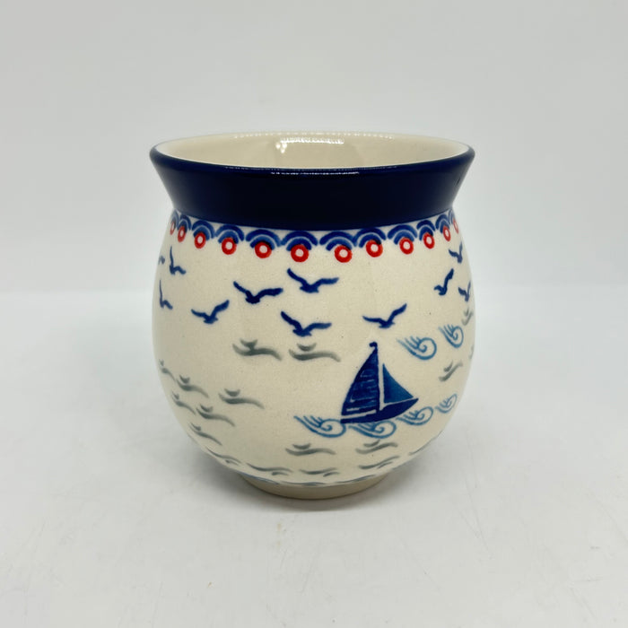 Side view of an 11oz Ceramika Artystyczna Polish pottery bubble mug in the Unikat U5164 pattern, featuring a hand-stamped blue sailboat, waves, and flying birds.
