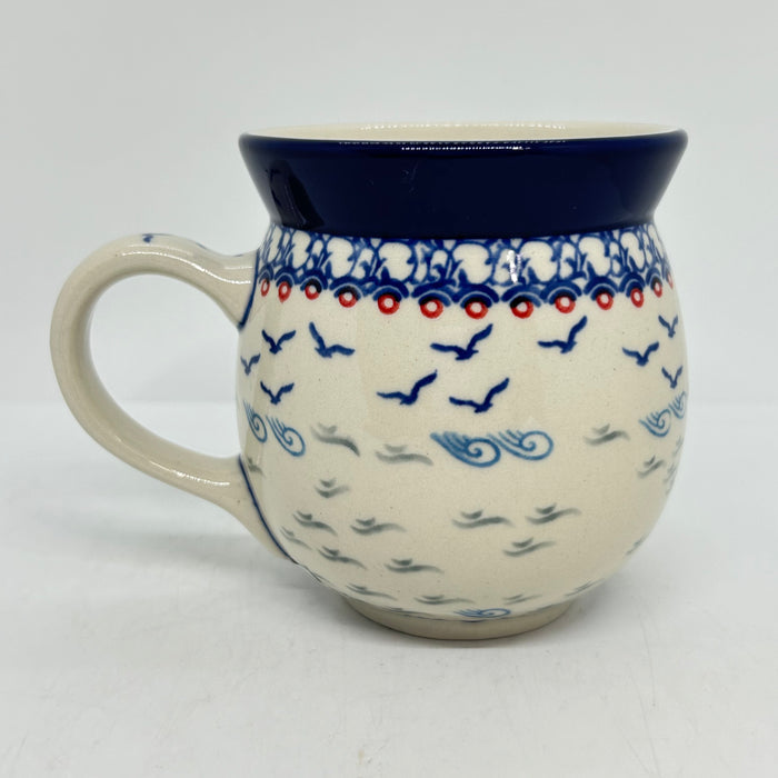 Back view of a large 16oz Ceramika Artystyczna Polish pottery bubble mug in the Unikat U5164 pattern, displaying the continuous hand-painted design of flying blue birds and waves.