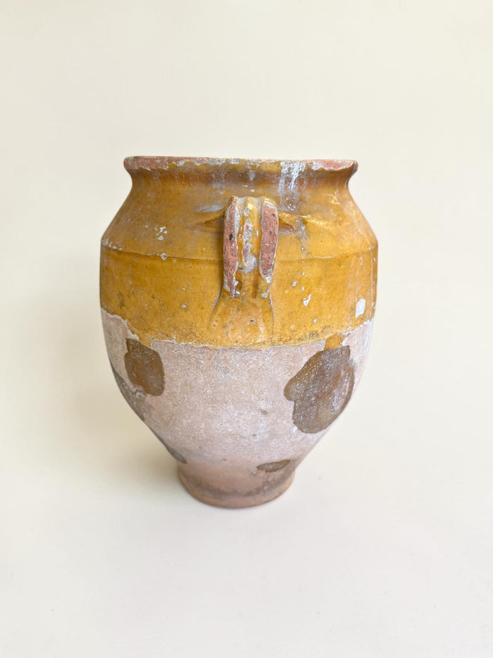 This is a 19th-century French terracotta confit pot with a partially yellow-glazed finish