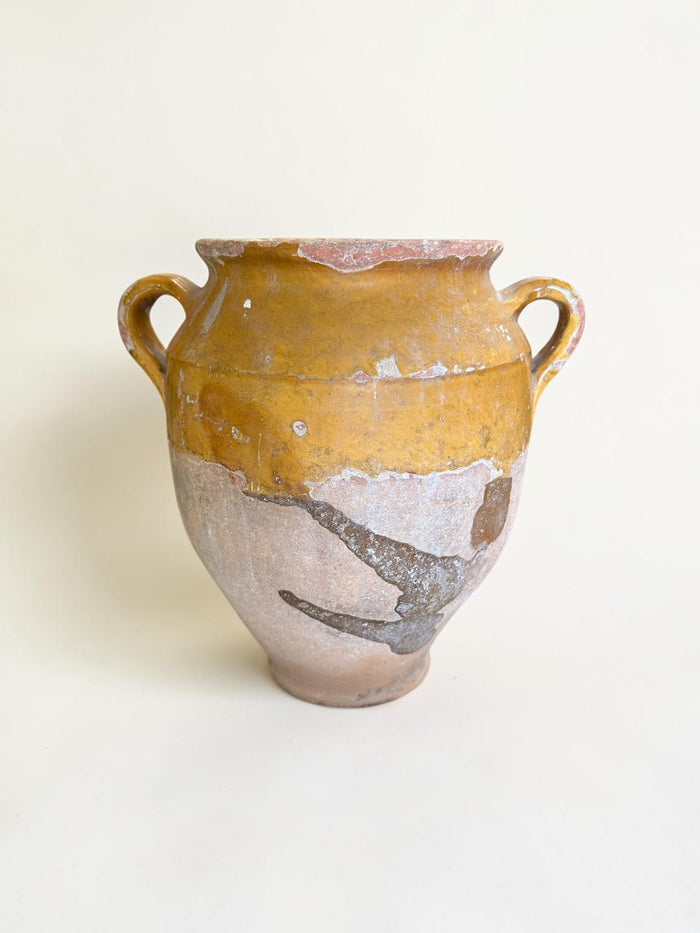 This is a 19th-century French terracotta confit pot with a partially yellow-glazed finish