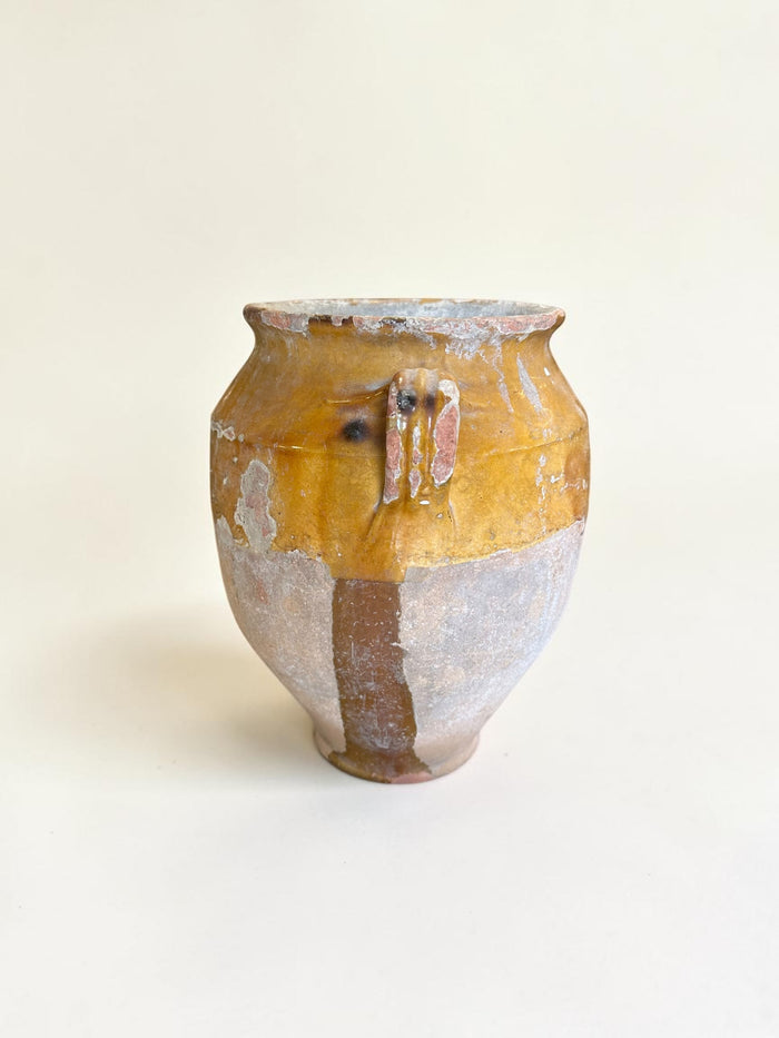 This is a 19th-century French terracotta confit pot with a partially yellow-glazed finish