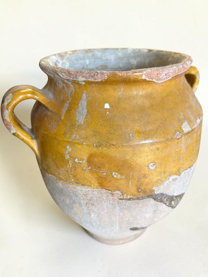 This is a 19th-century French terracotta confit pot with a partially yellow-glazed finish