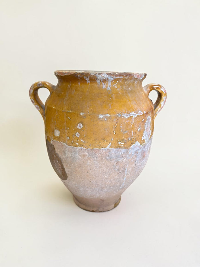 This is a 19th-century French terracotta confit pot with a partially yellow-glazed finish